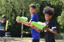 Rares Tausanu and Malachi Quayson having a water fight in Eaton Park during the heatwave