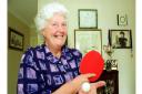 Mary Sawyer at home with a table tennis bat and ball.
