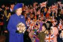 The Queen arrives at RAF Marham and is welcomed by local school children in 1996.