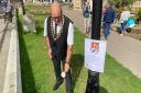 Cromer mayor Pat West pays tribute to the Queen by placing a flower in the garden outside the town\'s parish church.