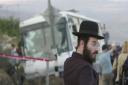 An Israeli orthodox Jewish man looks on as emergency workers work near a destroyed bus, at the scene of an attack against Israelis at the entrance to the Israeli settlement of Emmanuel, in the West Bank. Picture: AP Photo/Eitan Hess-Askenazi