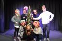 The Cinderella cast gather around the Christmas tree at Sheringham Little Theatre