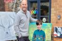Makers Gallery Holt co-owner and artist John Frith and William Hall, 8, stand in front of their respective paintings