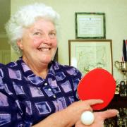 Mary Sawyer at home with a table tennis bat and ball.