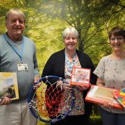 North Walsham hospital Friends chairman Keith Jarvis and treasurer Carol Willgress, right, present the activities to hospital inpatient administrator Wendy Russell