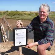 Ian Curtis, Stiffkey resident and bridge campaigner, with the sign put up by the National Trust at the 'fairy bridge'