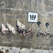 The vandalised Banksy in Cromer, on the sea wall near the beach huts at the east end of the town