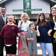 Sheringham Woodfields School business manager Matthew Smith MBE (left), with Lady Dannant MBE, the Lord Lieutenant of Norfolk (centre), headteacher Annette Maconochie (right) and children of the school