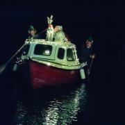 Santa and his helpers arriving by boat at Cley in north Norfolk